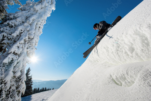 Low angle shot of a skier standing on top of a slope preparing for the ride blue sky on the background copyspace extreme active lifestyle leisure recreation concept freefide