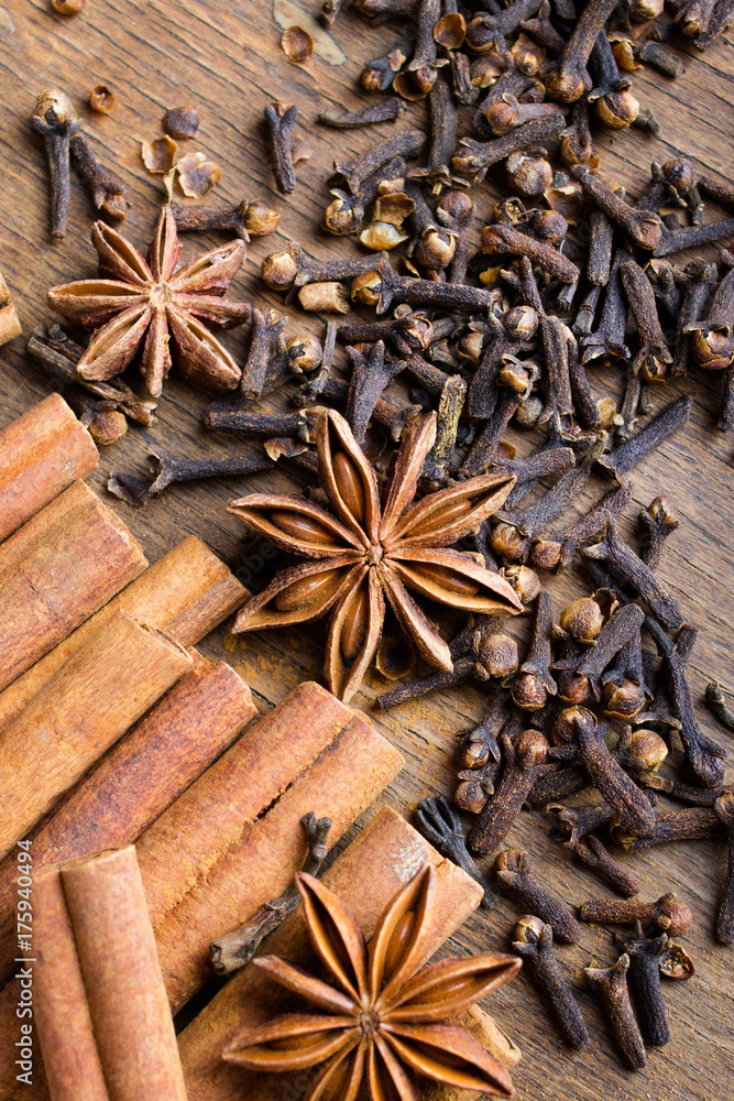 cinnamon sticks, star anise and cloves on wooden background cinnamon sticks, star anise and cloves on wooden background