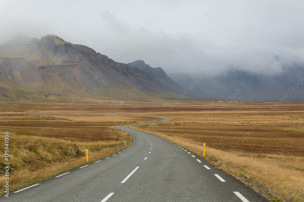 mäandernde Straße in Island vor Bergen im Dunst