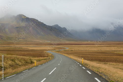 mäandernde Straße in Island vor Bergen im Dunst