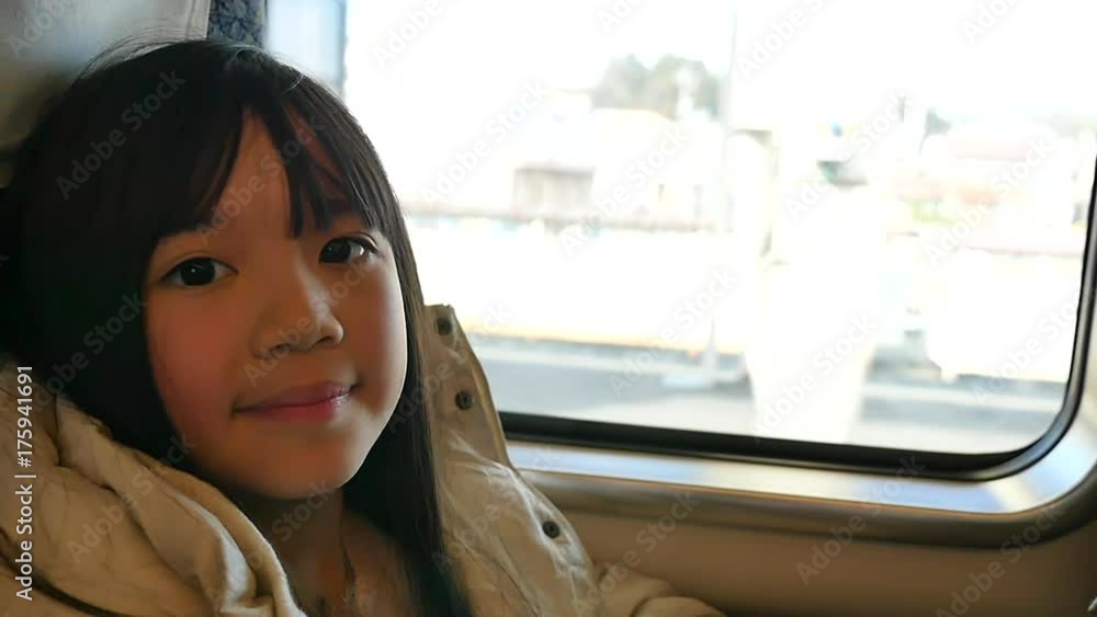 Little asian girl looking through window. She travels on a train slow motion Little asian girl looking through window. She travels on a train slow motion