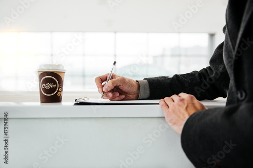 Young entrepreneur writes in a notebook with Cup of coffee