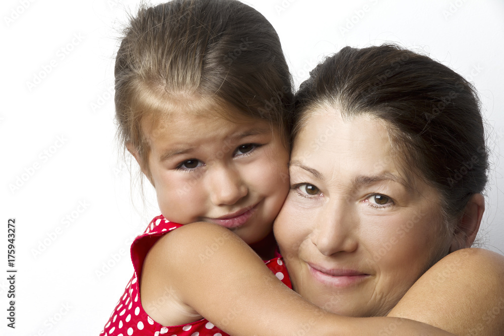 Affectionate grandmother and her cute little granddaughter smile at the camera Affectionate grandmother and her cute little granddaughter smile at the camera