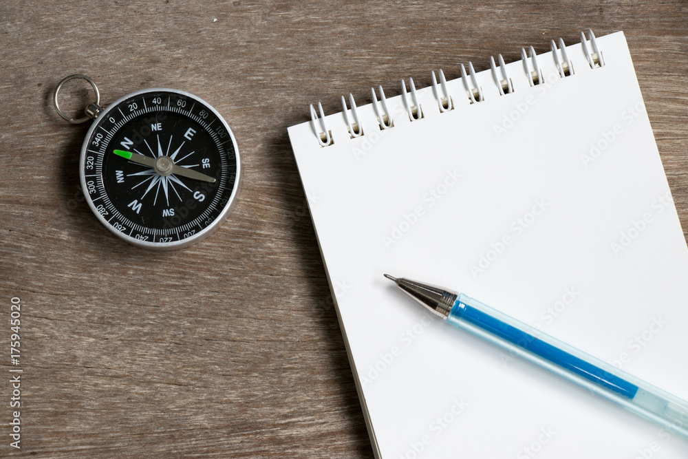 Blank note paper with compass on wood desk background Blank note paper with compass on wood desk background