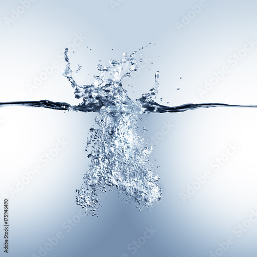 Dramatic blue water splash, water drops and air bubbles isolated on white