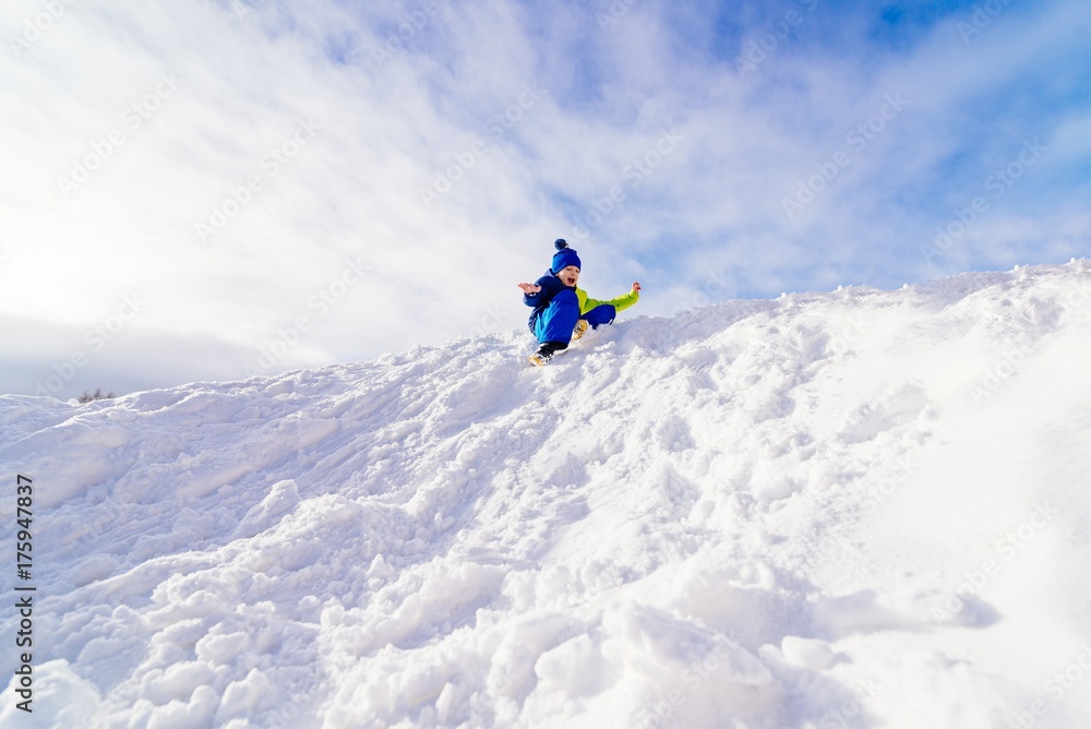 Child having fun at snowy hill.