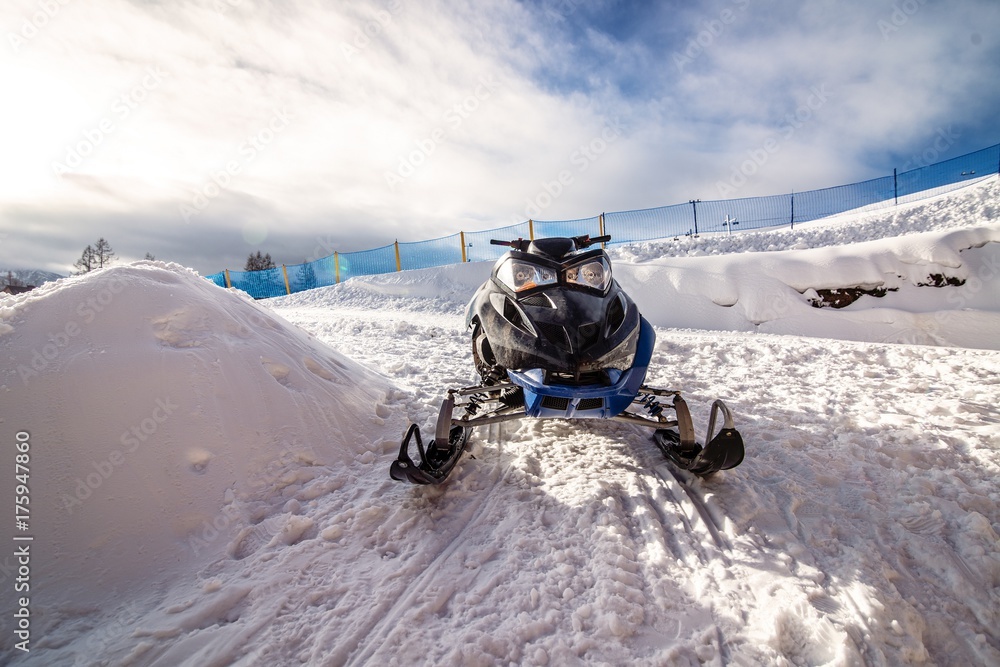 Obraz premium Black snowmobile on snow in Polish mountains.