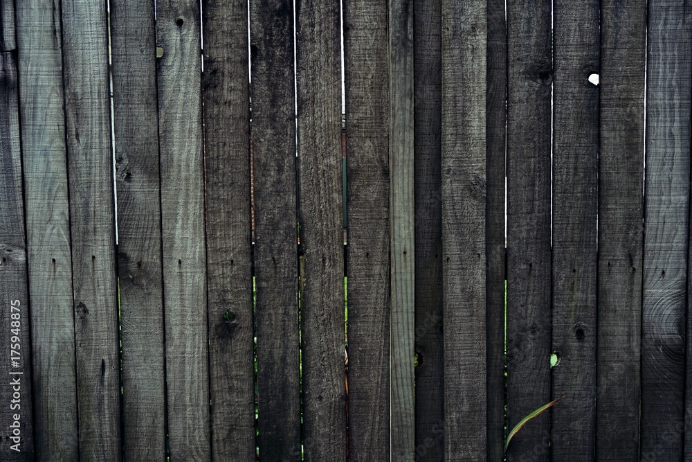 Fototapeta premium Close up of line dark brown wooden fence.striped wooden fence background.vertical wooden fence wall.