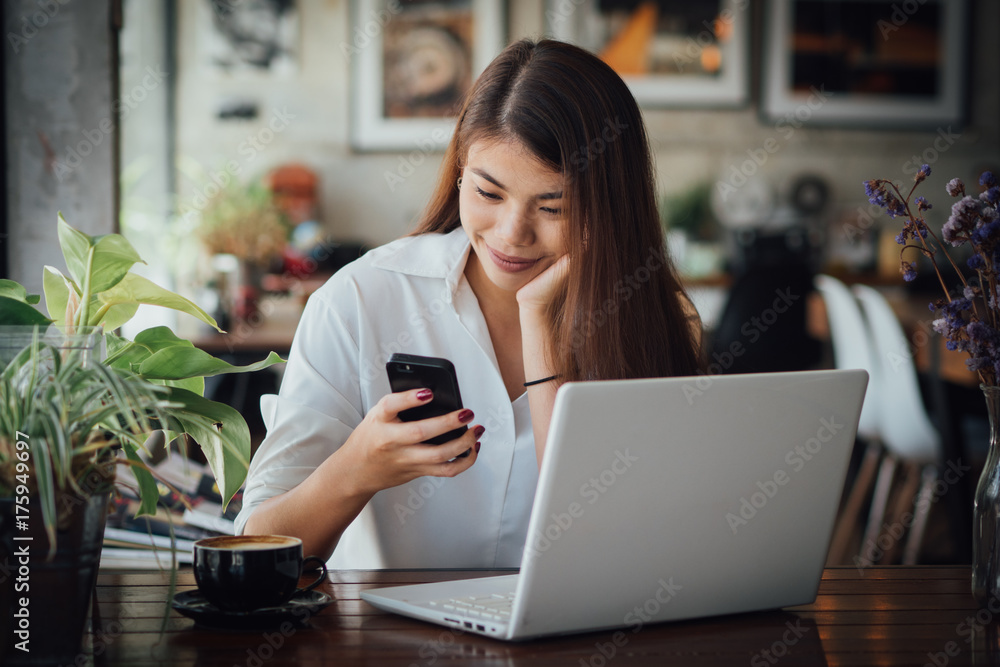 Asian business girl working and drinking coffee in cafe with laptop Asian business girl working and drinking coffee in cafe with laptop