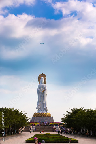 White GuanYin statue in Nanshan Buddhist Cultural Park, Sanya, Hainan Island, China. Buddhist goddess and the flying plane over it.