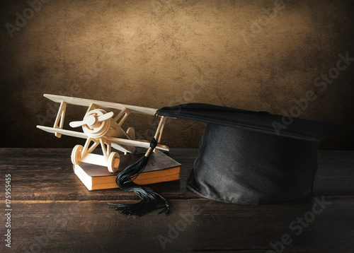 graduation cap, hat with wood toy airplane on wood table Empty ready for your product display or montage.