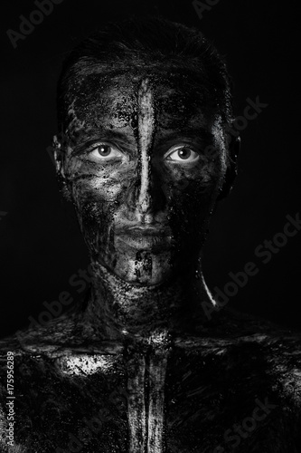 woman with black dirty smeared make up on black background, monochrome