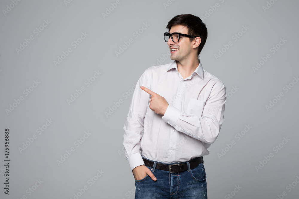 Handsome smiling man pointing away on gray background. Handsome smiling man pointing away on gray background.