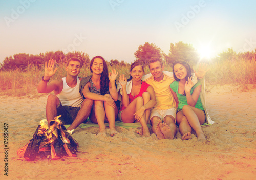 smiling friends in sunglasses on summer beach