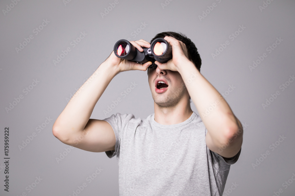 Young handsome man with binoculars isolated on white background Young handsome man with binoculars isolated on white background