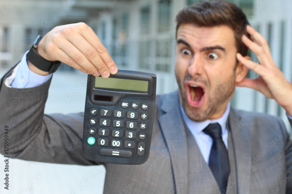Shocked businessman showing a calculator with space for copy Shocked businessman showing a calculator with space for copy