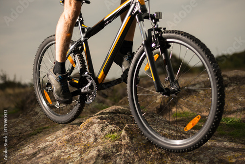 Close up Photo of Cyclist Riding Bike Down the Rock. Extreme Sport and Enduro Biking Concept.