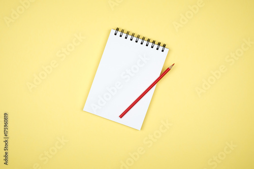 Top view of open spiral blank notebook on colorful desk