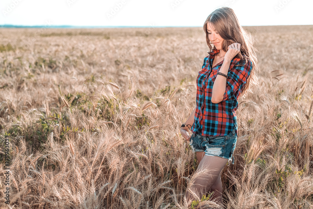 Girl in a field shirt shorts, wheat outdoor recreation, beautiful hair. A student walks after school. Girl in a field shirt shorts, wheat outdoor recreation, beautiful hair. A student walks after school.