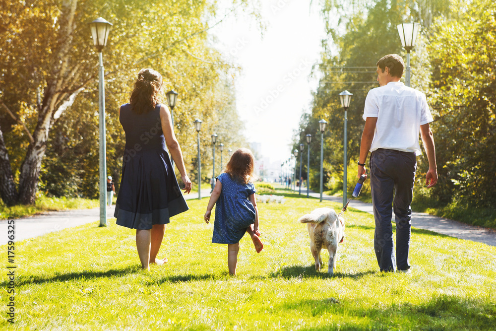 Obraz premium Happy family with dog walking in the Park