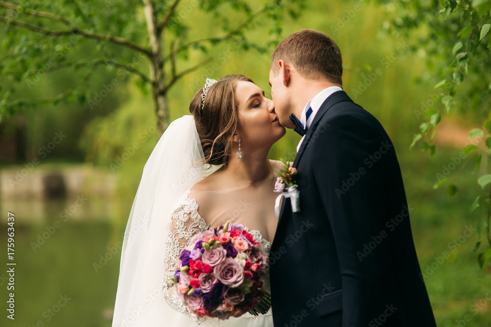Beautiful couple walking in the park in their wedding day Beautiful couple walking in the park in their wedding day
