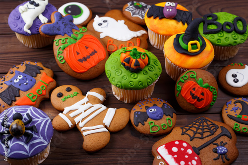 Halloween homemade gingerbread cookies and cupcakes background. Great assortment for treats at Halloween party. Halloween sweets, homemade confectionery, candy shop, holiday food