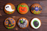 Halloween cookies set with funny decorations made of confectionery mastic on wooden kitchen table. Halloween sweets, homemade confectionery, holiday food, trick or treat concept