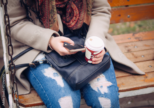girl sitting in Park with phone and coffee