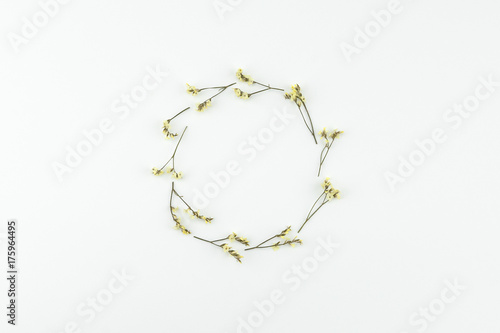 Round wreath made from yellow limonium caspia flowers on white background with copy space