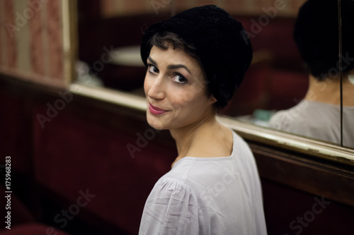 Portrait of a beautiful greek woman wearing a vintage black hat. photo