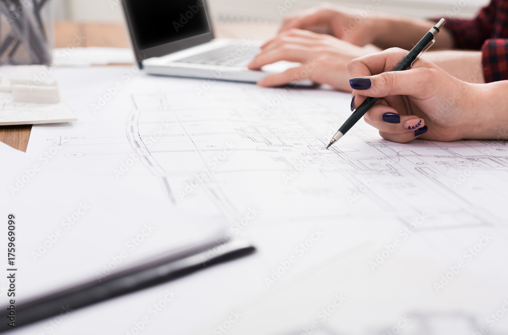 Unrecognizable architects discussing building plan Unrecognizable architects discussing building plan