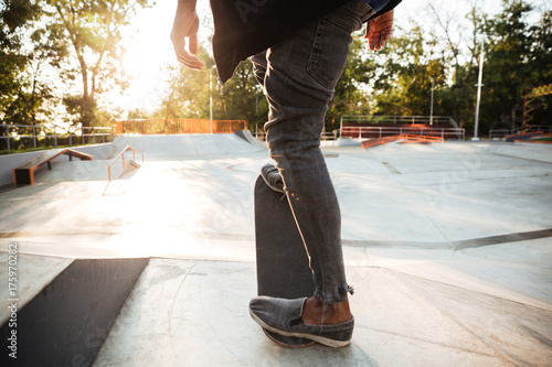 Cropped image of a young male teenager riding a skateboard © Drobot Dean