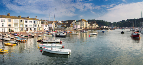 Panorama of the coast in the town of Teignmouth. Some people rest on the beach. Swim boats after a day's work.