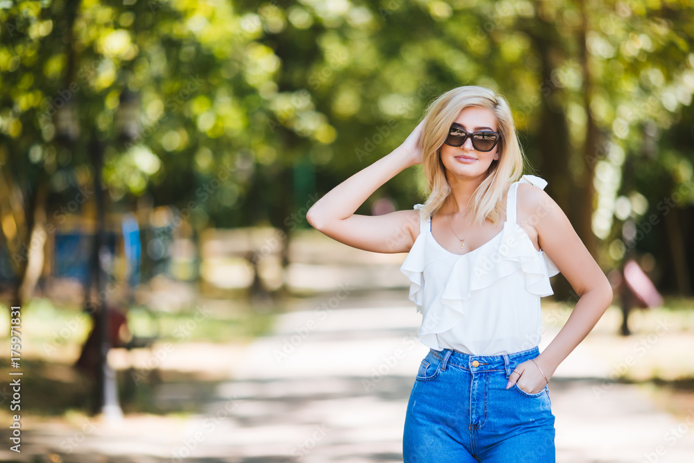 Young beautiful woman in sunglasses at sunny day in park Young beautiful woman in sunglasses at sunny day in park