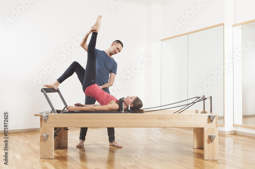 Pilates lesson on reformer, personal coaching young beautiful woman