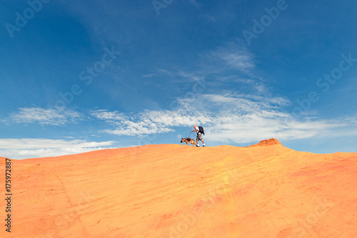 Man and dog walking on the edge of dune