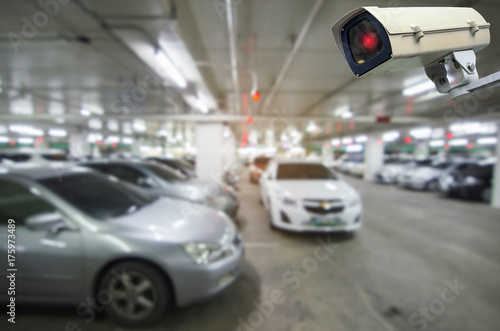 CCTV security indoor camera system operating with blurred image of under ground indoor car parking garage area, RFID solution management system, surveillance security and safety technology concept