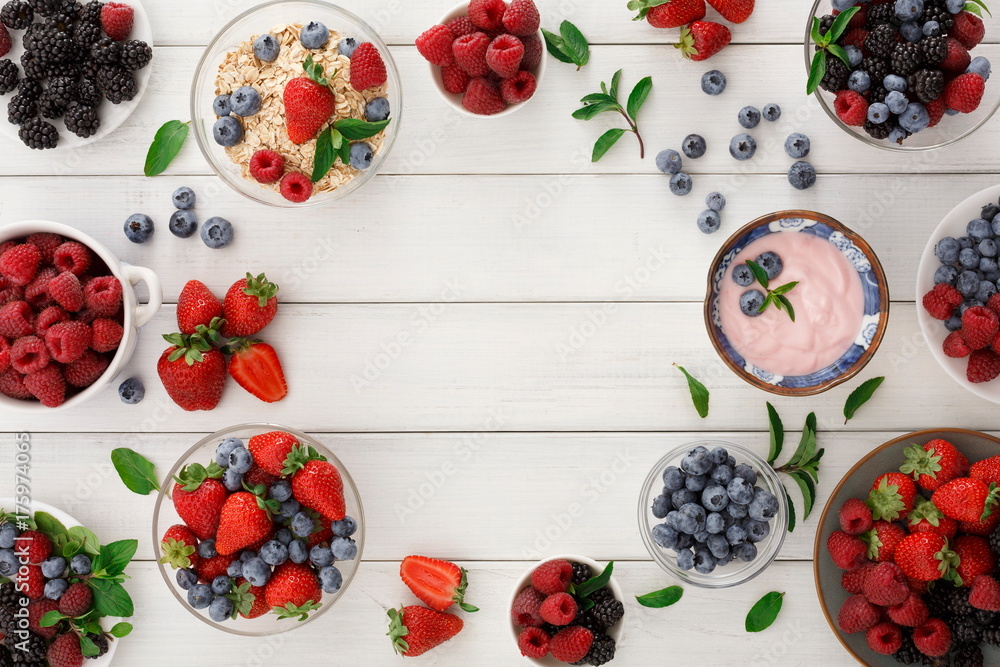 Healthy breakfast with berries and yogurt on white wooden table