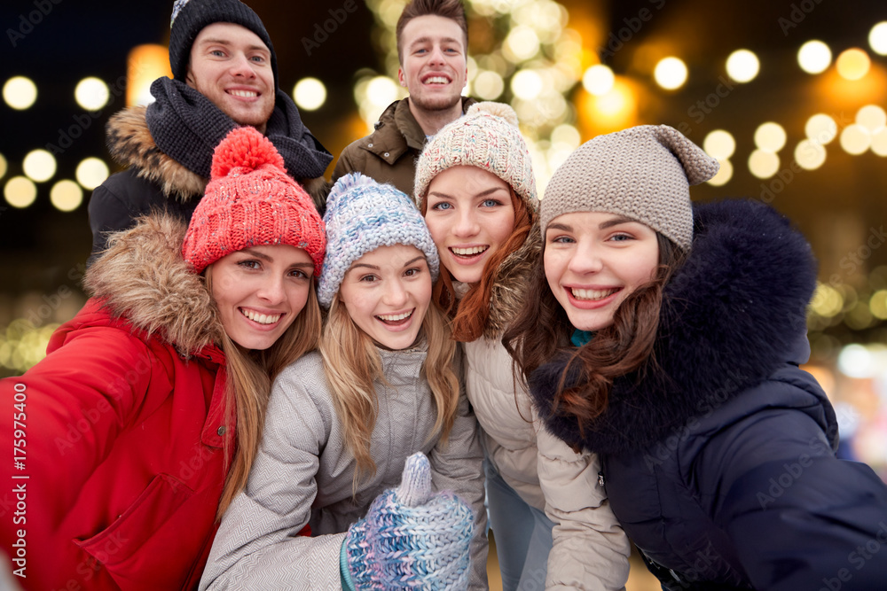 happy friends taking selfie outdoors at christmas happy friends taking selfie outdoors at christmas