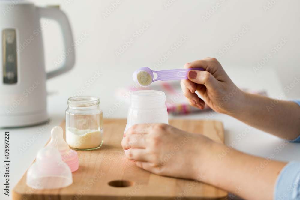 hands with bottle and scoop making formula milk hands with bottle and scoop making formula milk