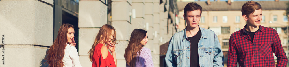 Group of young woman flirting with men in city. Friendship, leisure, student's lifestyle, first love, communication concept Group of young woman flirting with men in city. Friendship, leisure, student's lifestyle, first love, communication concept