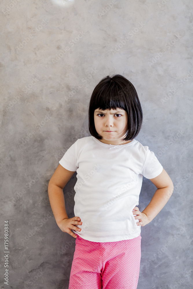 Frustrated black hair little girl by the wall Frustrated black hair little girl by the wall