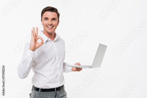 Portrait of a smiling handsome man holding laptop