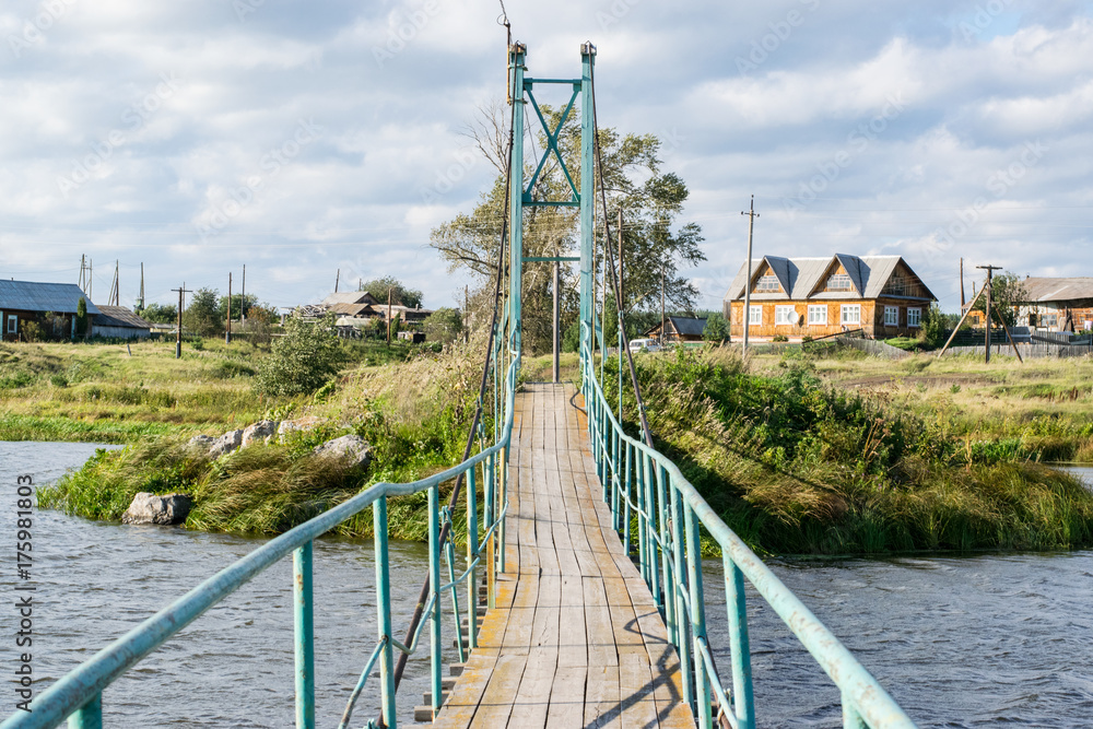 Russian rural landscape with a bridge over river