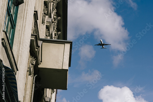 Flugzeug fliegt dicht über ein Wohnhaus mit Fluglärm Problem photo