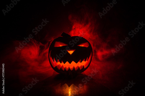 Halloween - old jack-o-lantern on black background. Spooky Halloween background with pumpkin