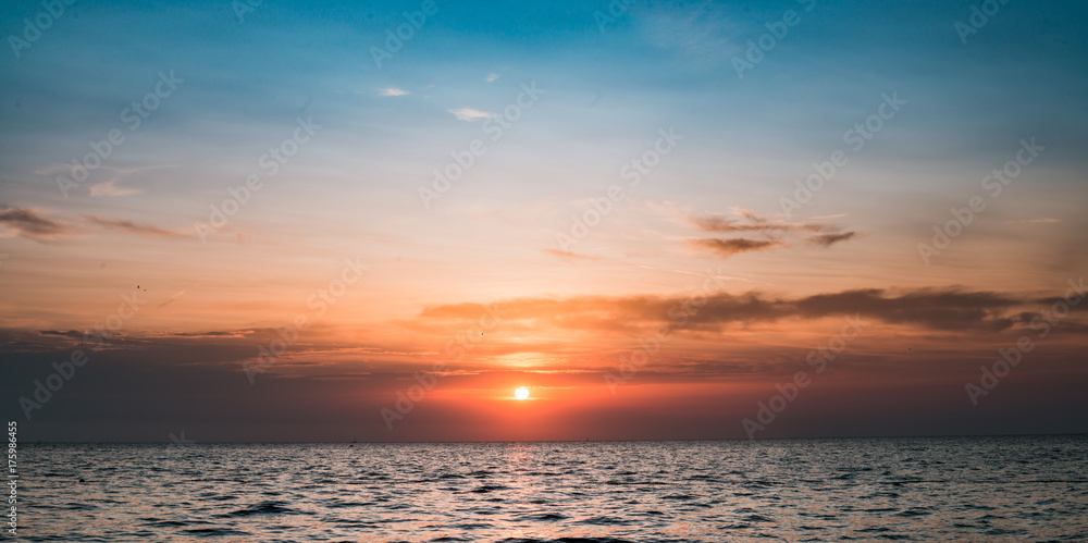 Cloudy layered sunset on the ocean. Background for peacefulness