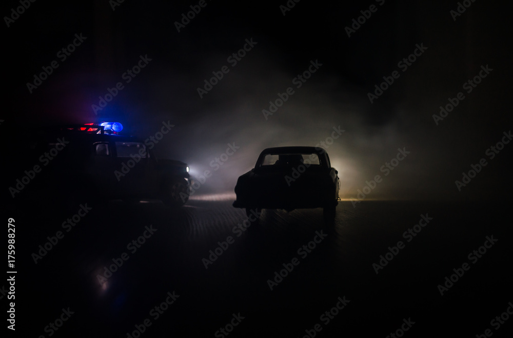 Police car chasing a car at night with fog background. 911 Emergency response police car speeding to scene of crime Police car chasing a car at night with fog background. 911 Emergency response police car speeding to scene of crime