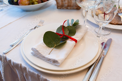 A serving plate with tissue paper and a decorative sheet of paper taped. Knives and Fork. Table setting in the restaurant. photo