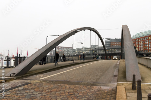 Foggy winter day view of the bridge from Bauwall train station to Speicherstad district in Hamburg Germany photo